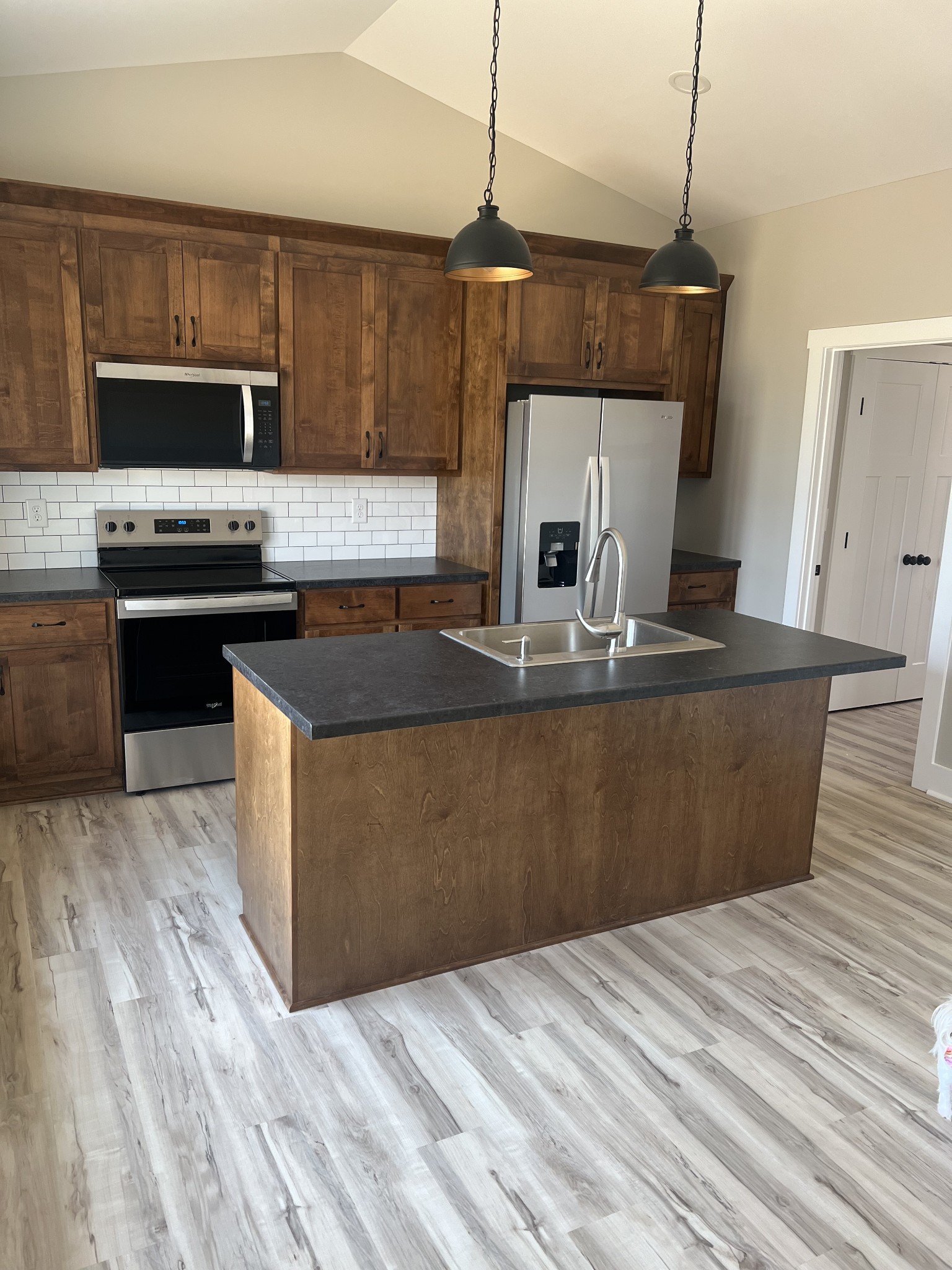 401 Hawkins Street Cowan, TN 37318 - Photo 5 of 15 a kitchen with kitchen island granite countertop a stove a sink and a microwave