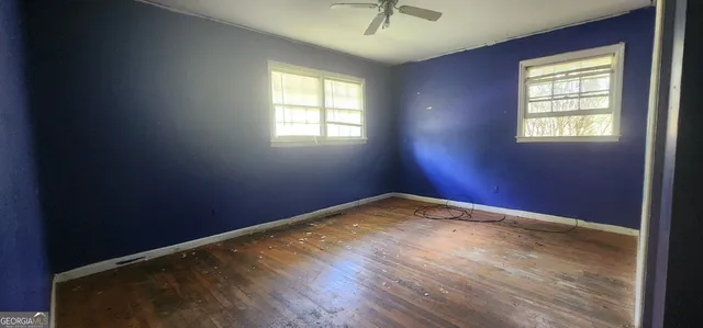 a view of empty room with wooden floor