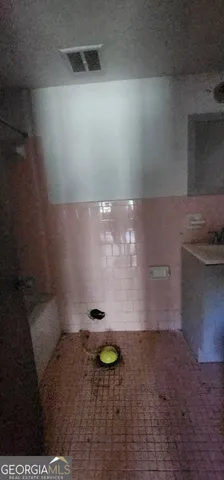 a bathroom with a granite countertop sink and washing machine