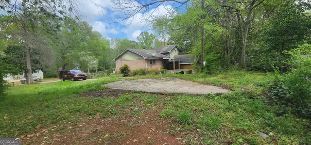 a front view of a house with a yard and trees