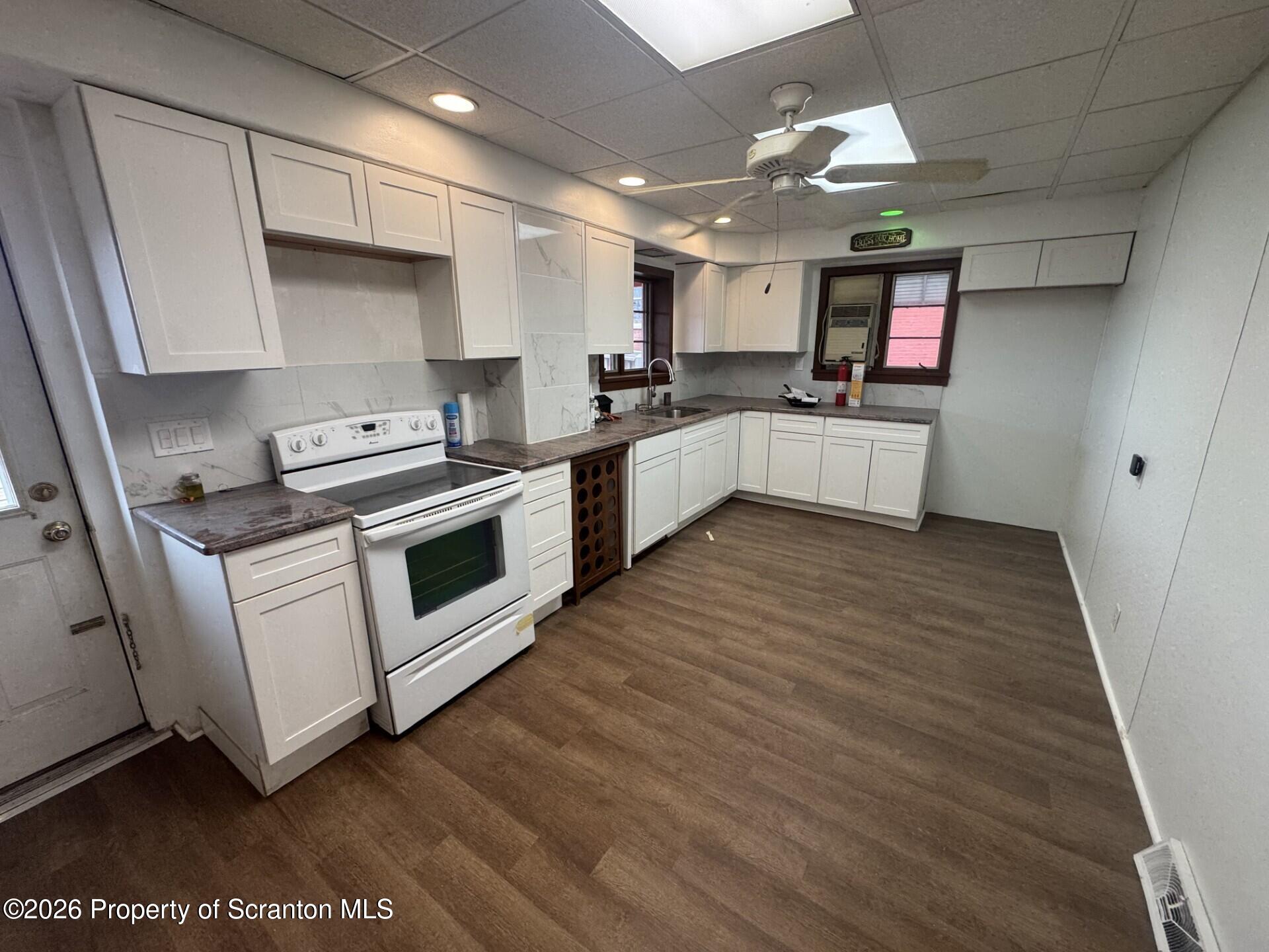 209 South Main Avenue Scranton, PA 18504 - Photo 4 of 12 a kitchen with stainless steel appliances white cabinets a sink a stove a refrigerator and a microwave