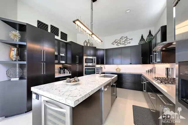 a kitchen with stainless steel appliances kitchen island granite countertop a sink and cabinets