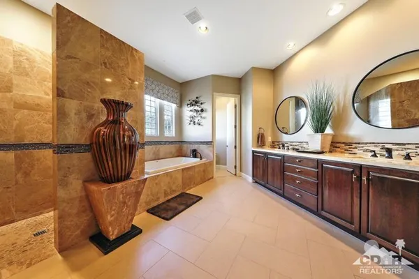 a en suite bathroom with a granite countertop sink and a mirror