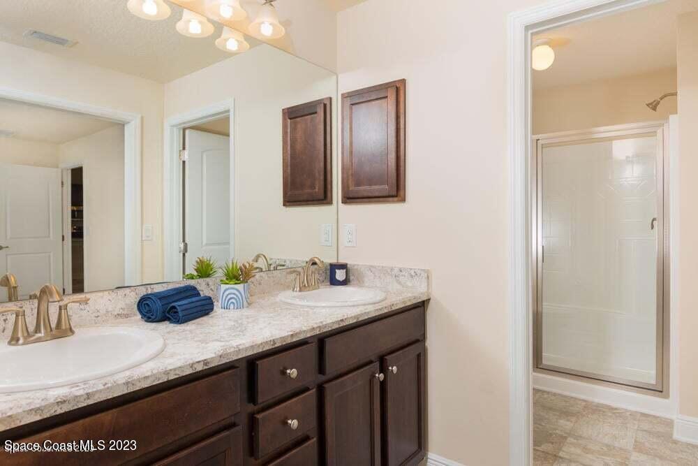 338 Garvey Road Palm Bay, FL 32908 - Photo 8 of 12 a bathroom with a granite countertop double vanity sink and a mirror