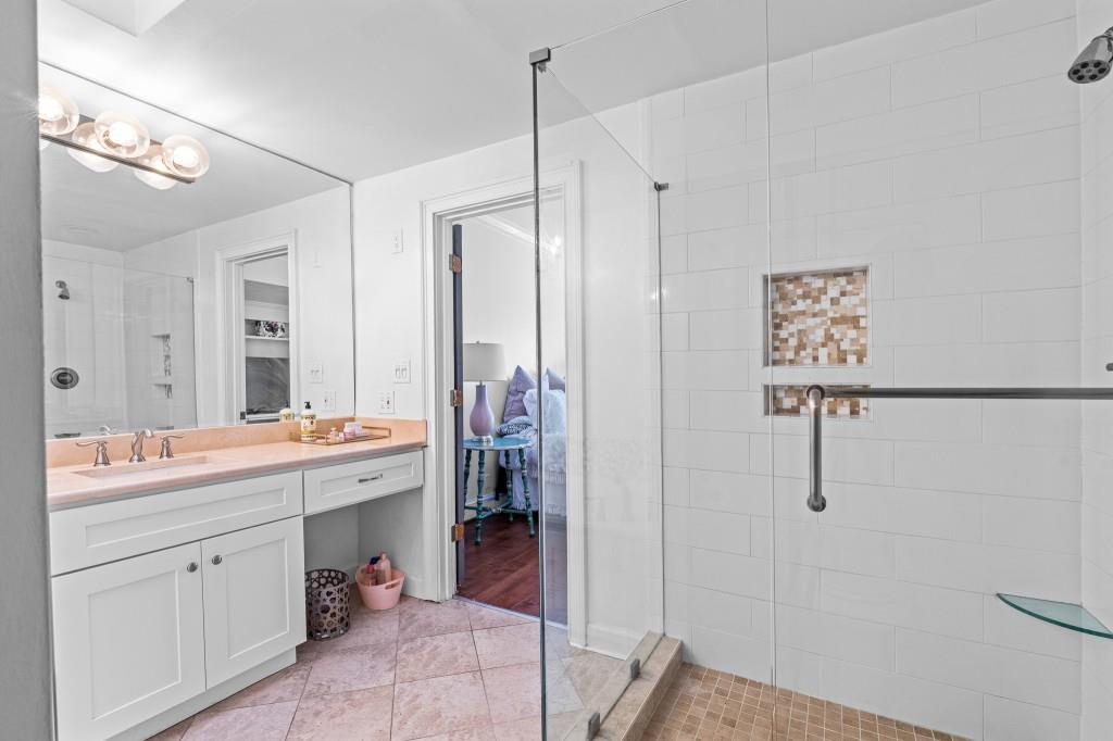 3638 Peachtree Road Northeast, Unit 406 Atlanta, GA 30319 - Photo 20 of 27 a bathroom with a double vanity sink toilet and mirror
