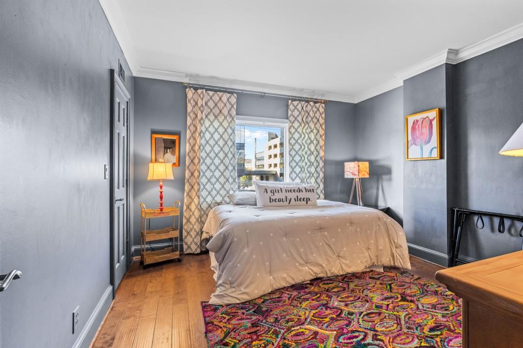 3638 Peachtree Road Northeast, Unit 406 Atlanta, GA 30319 - Photo 21 of 27 a bedroom with a bed and wooden floor
