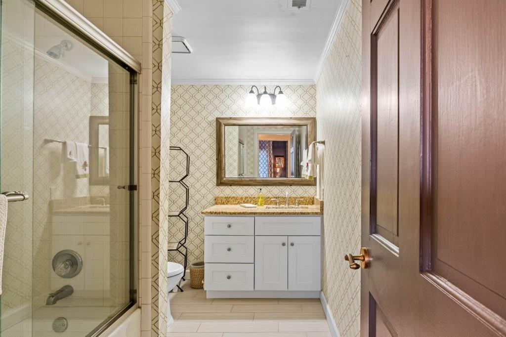 3638 Peachtree Road Northeast, Unit 406 Atlanta, GA 30319 - Photo 22 of 27 a bathroom with a granite countertop sink a mirror and shower