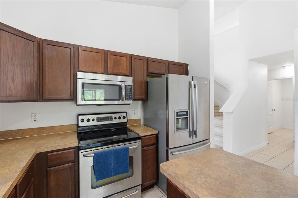 12005 Infinity Drive New Port Richey, FL 34654 - Photo 10 of 48 a kitchen with stainless steel appliances a stove a microwave and a refrigerator