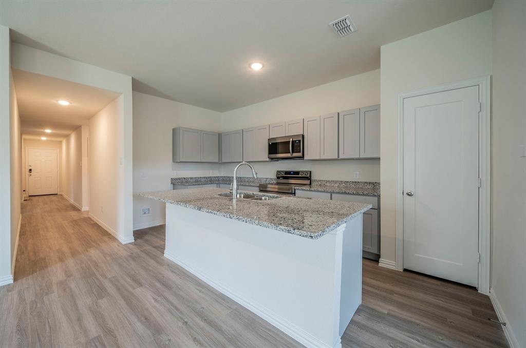 118 Goel Street Greenville, TX 75402 - Photo 3 of 12 a kitchen with stainless steel appliances granite countertop a sink stove and refrigerator