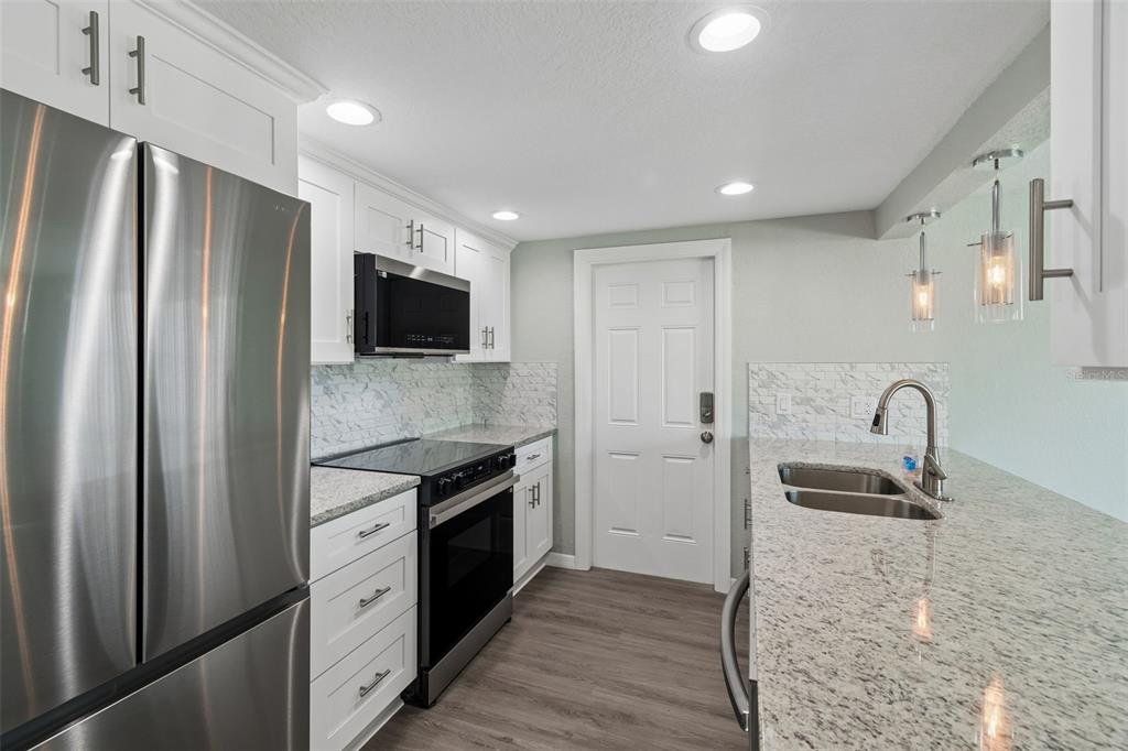 4417 Rudder Way New Port Richey, FL 34652 - Photo 2 of 47 a kitchen with stainless steel appliances granite countertop a refrigerator and a sink