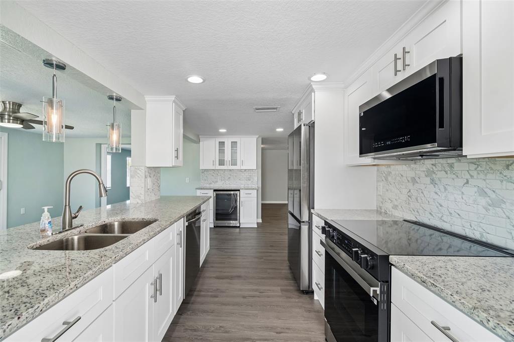 4417 Rudder Way New Port Richey, FL 34652 - Photo 3 of 47 a kitchen with stainless steel appliances granite countertop a sink a stove top oven and granite counter tops