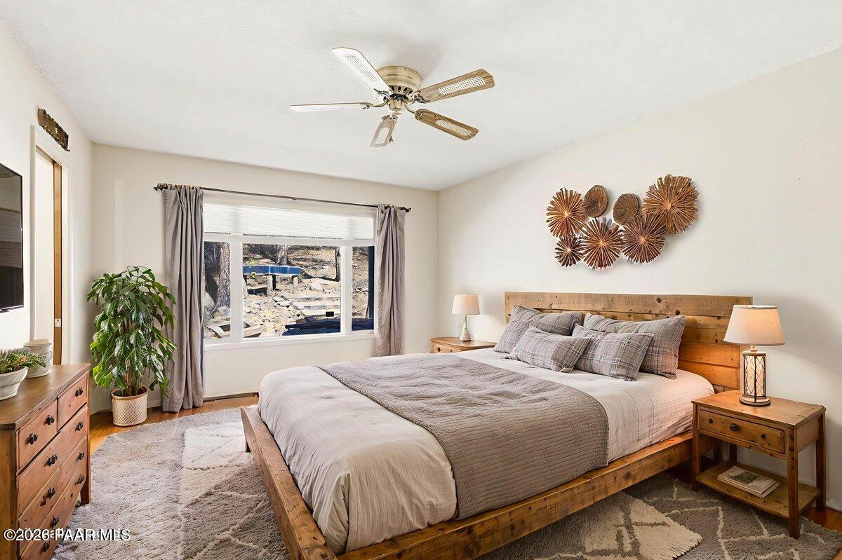 748 East Marapai Road Prescott, AZ 86303 - Photo 22 of 47 a bedroom with a large bed and a chandelier