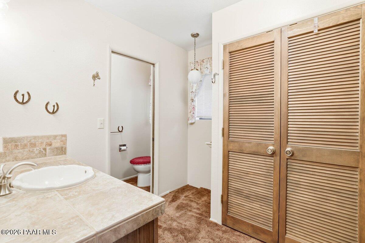 748 East Marapai Road Prescott, AZ 86303 - Photo 25 of 47 a bathroom with a granite countertop sink a toilet and shower