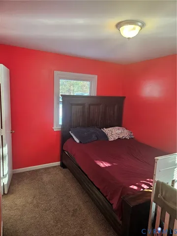 a bed sitting in a room next to a lamp