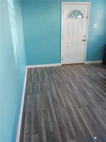 a view of a small space with wooden floor and a door