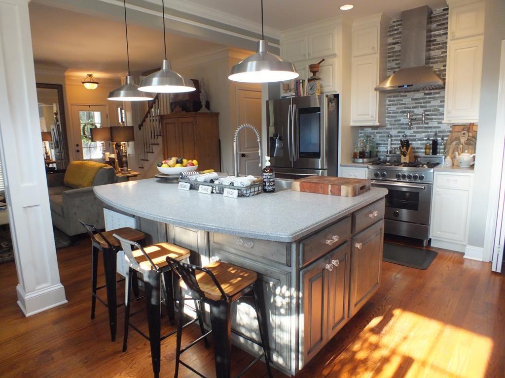 5641 Tucker Road Ooltewah, TN 37363 - Photo 19 of 53 a kitchen with a stove a sink a kitchen island with chairs and wooden floor