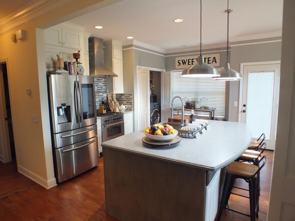 5641 Tucker Road Ooltewah, TN 37363 - Photo 20 of 53 a kitchen with a refrigerator a stove and a dining table with wooden floor