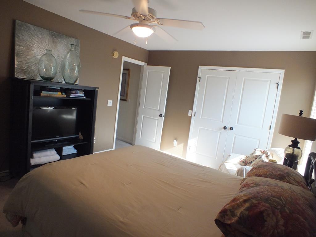 5641 Tucker Road Ooltewah, TN 37363 - Photo 38 of 53 a bedroom with a bed and a flat tv screen on dresser
