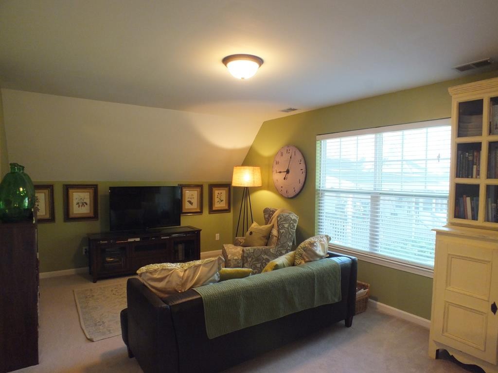 5641 Tucker Road Ooltewah, TN 37363 - Photo 49 of 53 a living room with furniture a large window and a flat screen tv