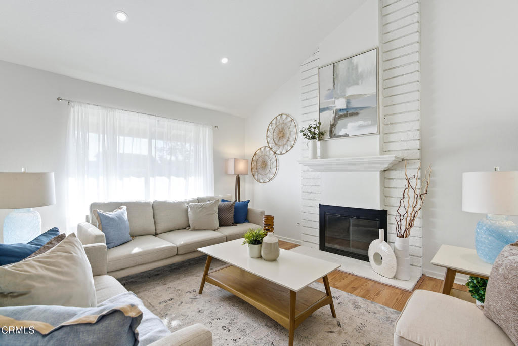 a living room with furniture a fireplace with a large window