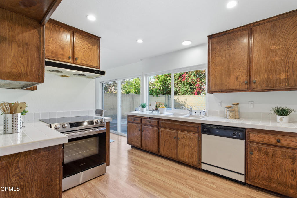 13151 Rose Street Cerritos, CA 90703 - Photo 10 of 24 a kitchen with stainless steel appliances granite countertop wooden cabinets stove top oven and sink