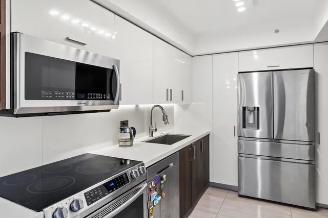 a kitchen with stainless steel appliances a refrigerator a sink and a stove
