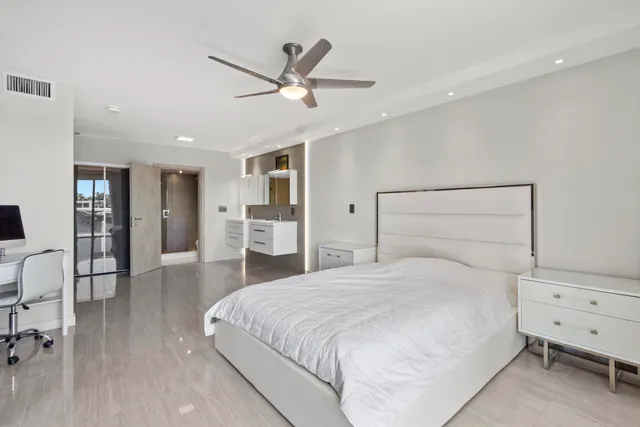 a bedroom with a large bed and painting on the wall