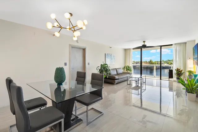a living room with furniture a chandelier and a large window