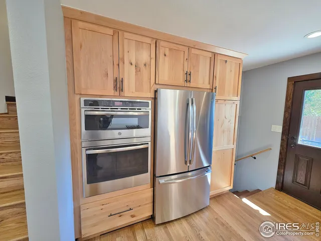 a view of kitchen with refrigerator cabinets and wooden floor