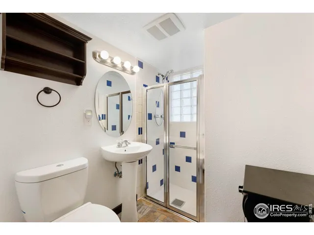a bathroom with a sink a toilet a mirror and shower