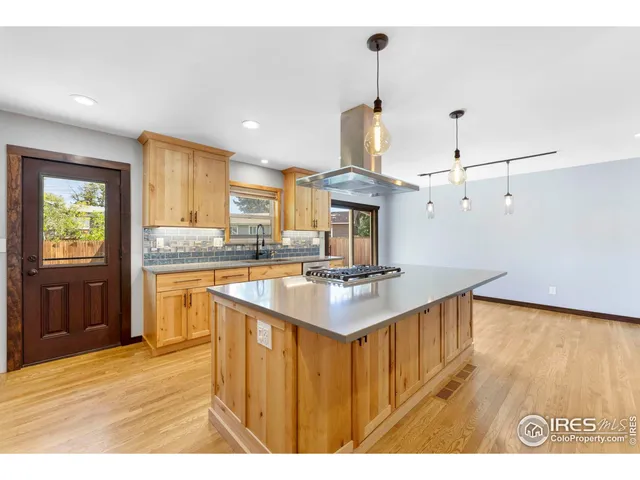 a kitchen with kitchen island granite countertop a sink appliances and cabinets