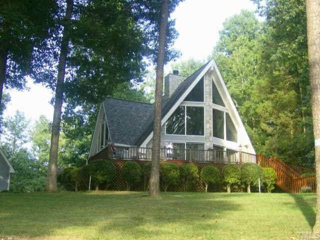 313 Fishermans Road Roxboro, NC 27574 - Photo 1 of 1 a view of a white house next to a yard with big trees