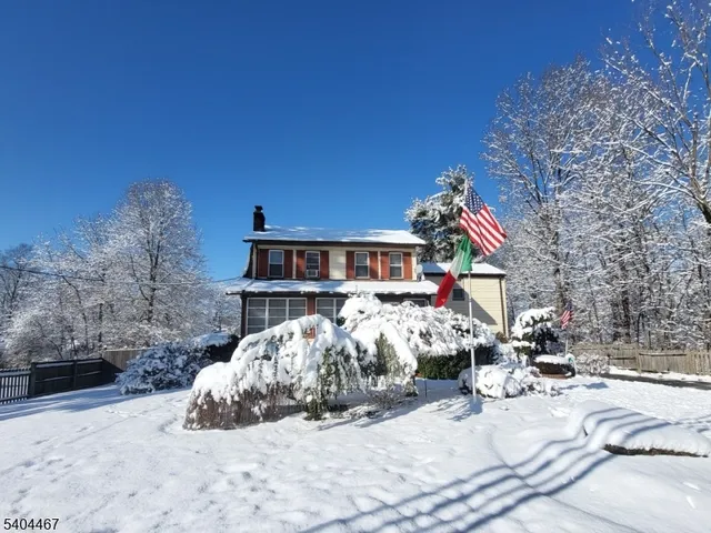 a view of a house with a yard covered in snow