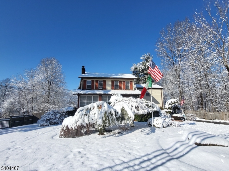 a view of a house with a yard covered in snow