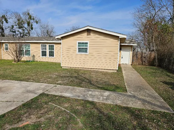 a view of a yard in front of a house with a large tree