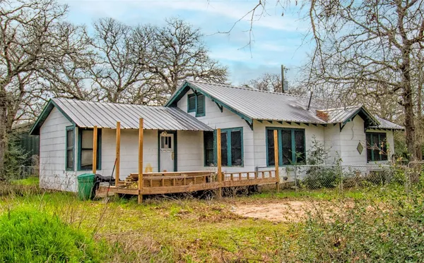 a front view of house with yard and trees around