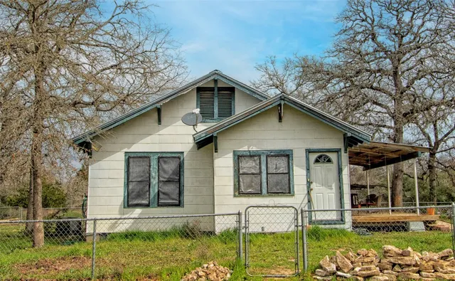 a view of house with yard and outdoor seating