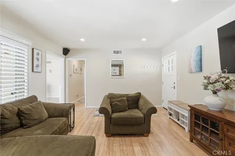 a living room with furniture a fireplace a flat screen tv and potted plant