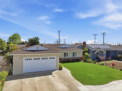 a front view of a house with a garden and plants