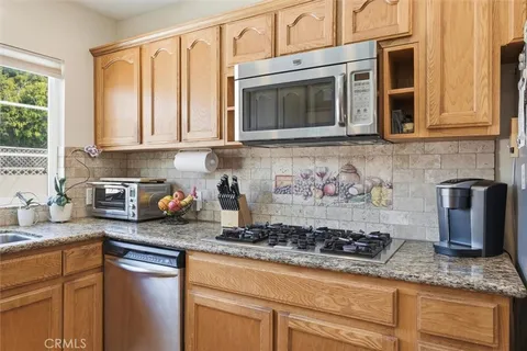 a kitchen with stainless steel appliances granite countertop a sink stove and cabinets