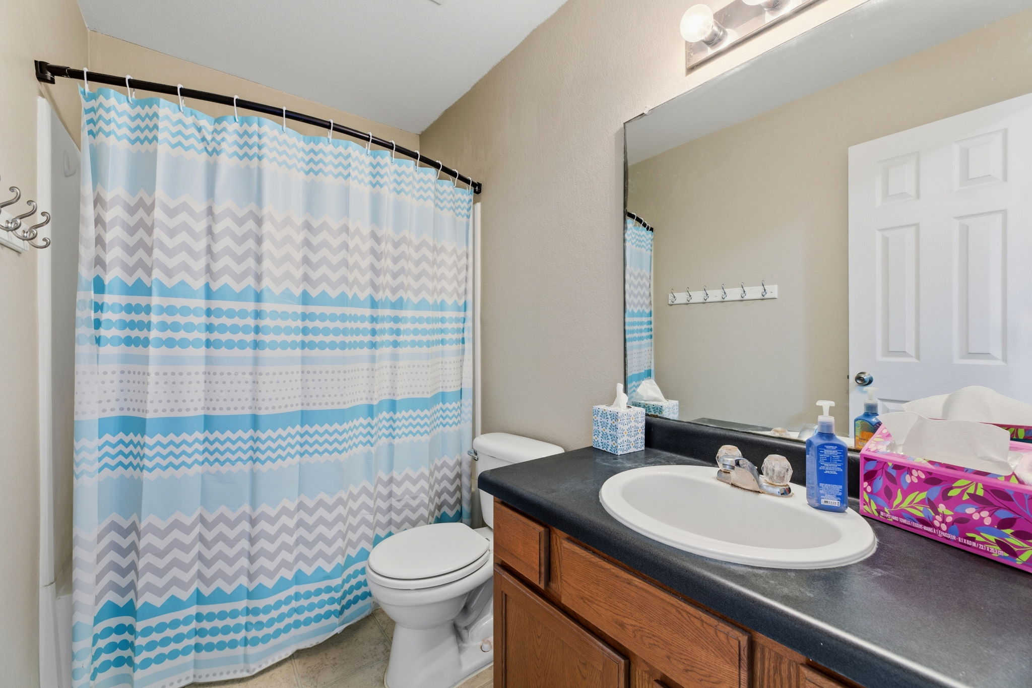 12601 Waynespur Lane Elgin, TX 78621 - Photo 14 of 38 A well-appointed bathroom features a single vanity, ample mirror, and a convenient shower-tub combination.