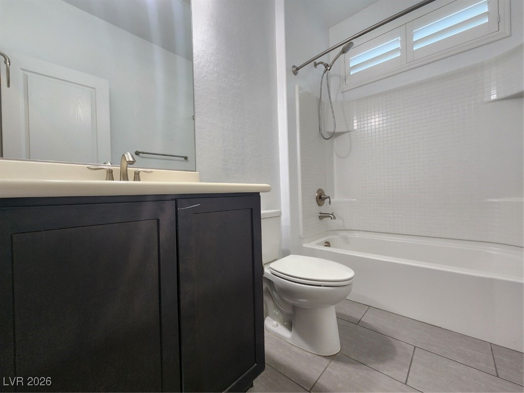 7022 Cordite Road Las Vegas, NV 89178 - Photo 15 of 51 Bathroom featuring tub / shower combination, vanity, a textured wall, and light tile patterned floors