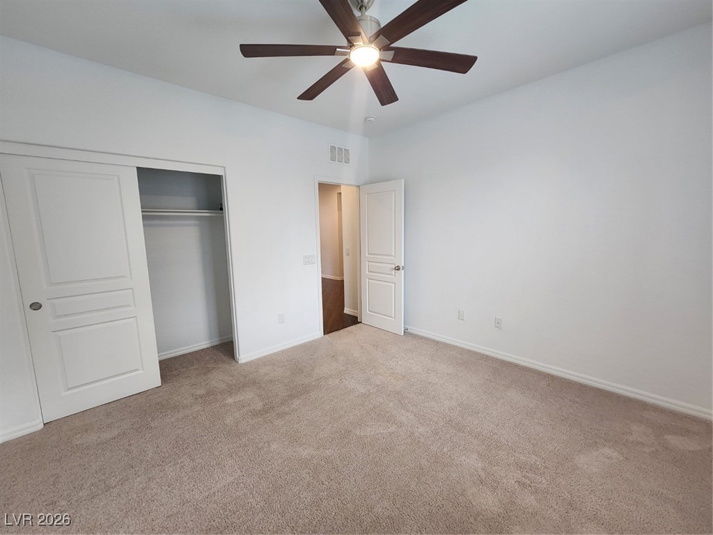 7022 Cordite Road Las Vegas, NV 89178 - Photo 18 of 51 Unfurnished bedroom featuring light colored carpet, a closet, and a ceiling fan