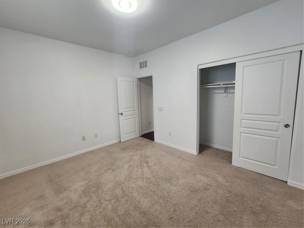 7022 Cordite Road Las Vegas, NV 89178 - Photo 24 of 51 Unfurnished bedroom with light colored carpet and a closet