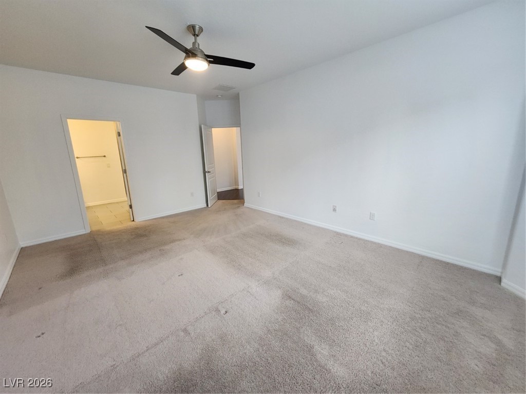 7022 Cordite Road Las Vegas, NV 89178 - Photo 30 of 51 Unfurnished bedroom with a ceiling fan, light carpet, and ensuite bath