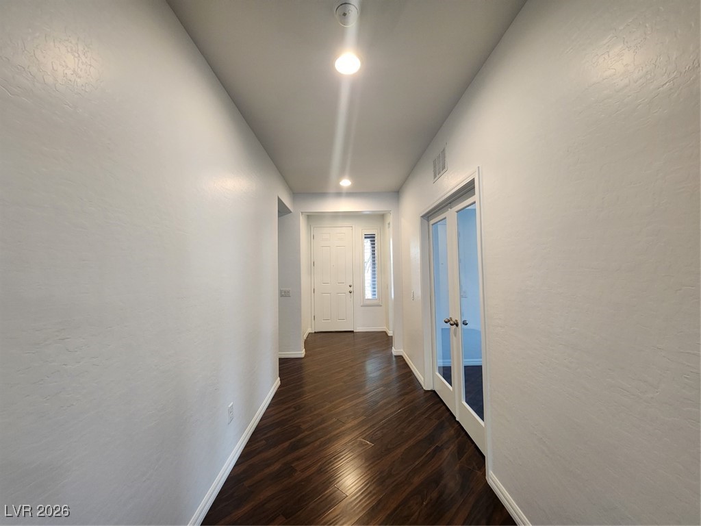 7022 Cordite Road Las Vegas, NV 89178 - Photo 4 of 51 Hallway with dark wood-style floors, a textured wall, french doors, and recessed lighting