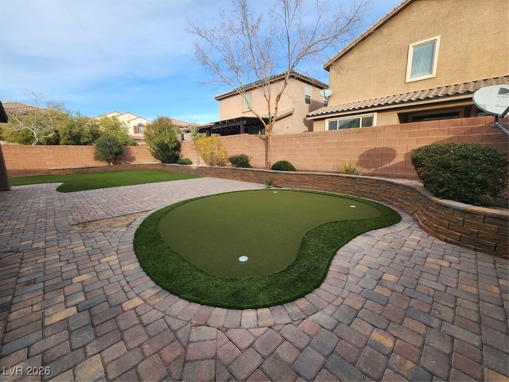 7022 Cordite Road Las Vegas, NV 89178 - Photo 44 of 51 View of property's community with a putting area, a fenced backyard, and a patio area