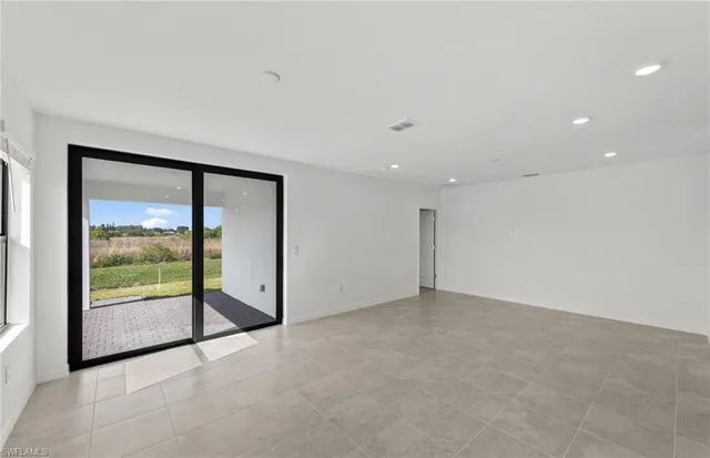 an empty room with floor to ceiling window and an outdoor view