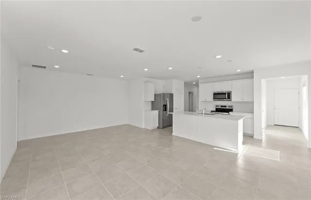 a view of kitchen with kitchen island white cabinets and refrigerator