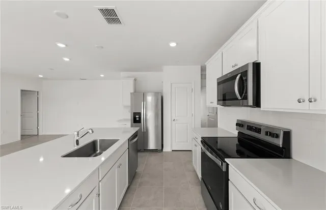 a kitchen with stainless steel appliances kitchen island granite countertop a sink and a stove
